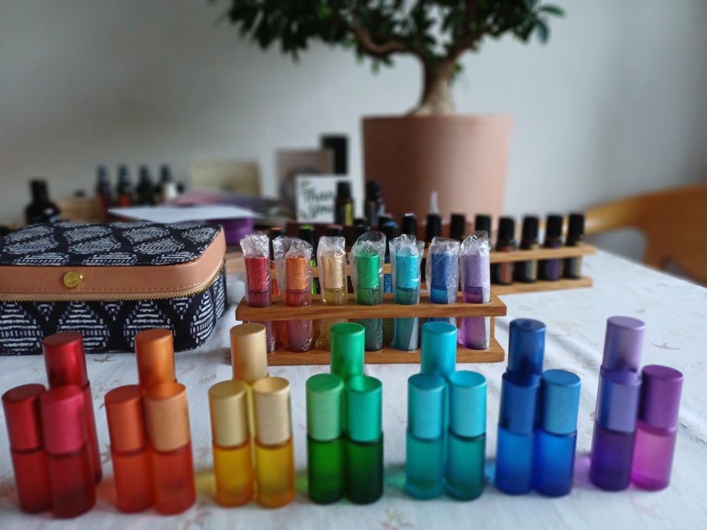 Seven chakra essences in rainbow colours on a wooden stand